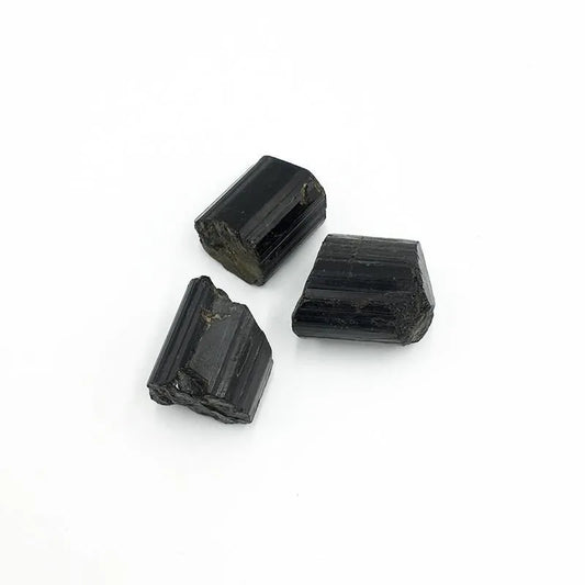 Black Tourmaline Raw Chunk Three black stone beads on a white background