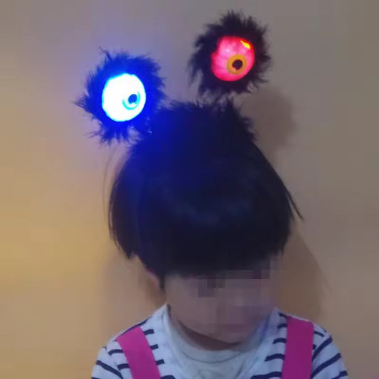 LED Wiggly Eye Head Boppers A child wearing a black fuzzy headband with two glowing, multi-colored eyeball designs.