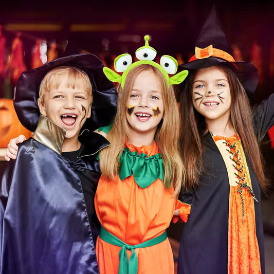 Alien Eyeball Headband three children dressed in Halloween costumes, with the middle girl wearing a green three-eyed alien character headband.