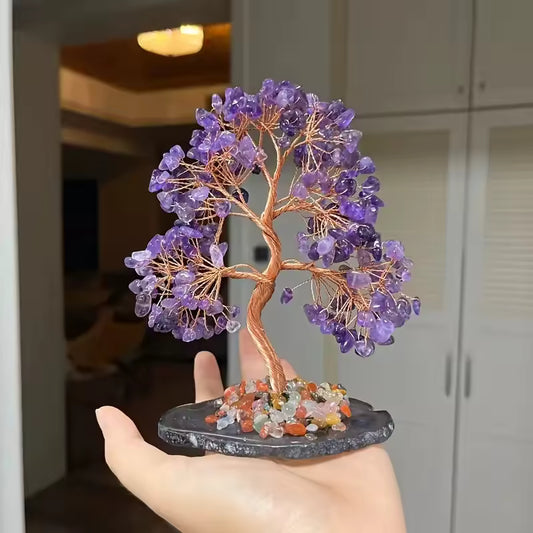 Amethyst Crystal Tree Crystal tree figurine with purple stones held in a hand indoors.