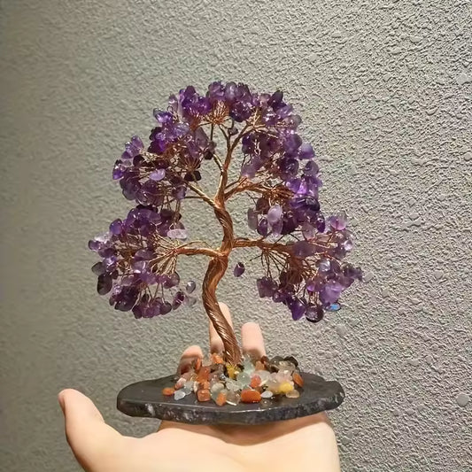 Amethyst Crystal Tree Amethyst crystal tree on a dark base held by a hand against a neutral background