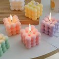 Bubble Cube Candle burning
GiftDealAU product image.Bubble-shaped candles in various colors on a light surface.