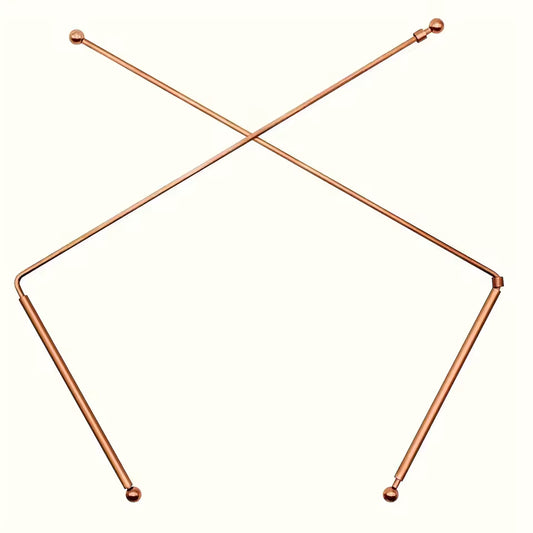 Copper Dowsing Rods A pair of metallic copper-colored metal pole supports with ball tips, arranged in a crossed V-shape on a plain off-white background.