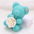 Crystal Diamond Bear Turquoise teddy bear with a white rose and tiara on a white background