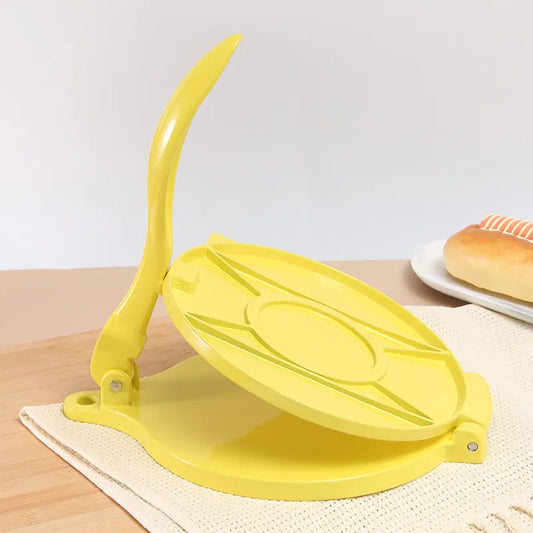 Davis & Waddell Tortilla Press Yellow tortilla press on a wooden surface with a white background