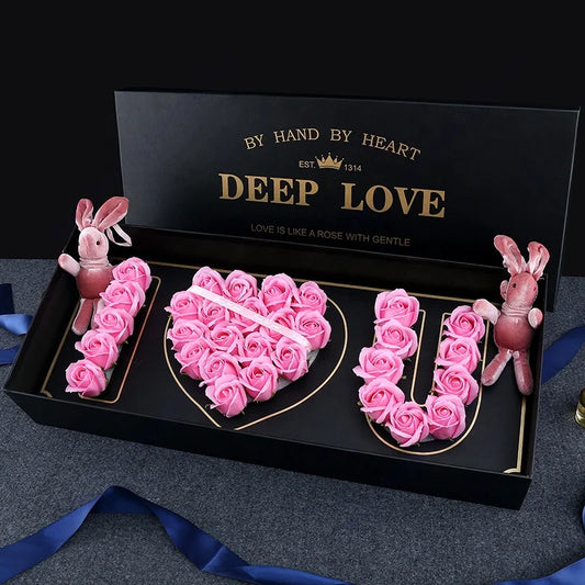 Deep Love I Love You Rose Gift Box Decorative set with pink roses spelling 'LOVE' and bunnies in a black box labeled 'By Hand by Heart Deep Love'.