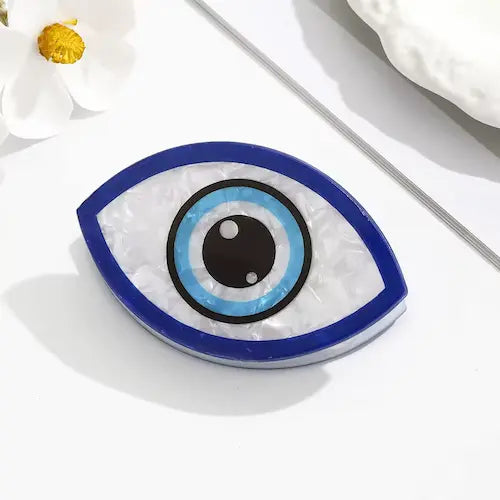 Evil Eye Hair Claw Clip GiftDealAU product image. Decorative eye-shaped object with blue and black design on a white surface with flowers.