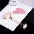 Pink facial roller and gua sha tool on a white grid surface with a container labeled 'Blue Mountain' in the background.