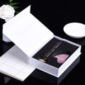 Facial Roller and Gua Sha Gift Set Jewelry set in an open box with a white rose and notebook in the background