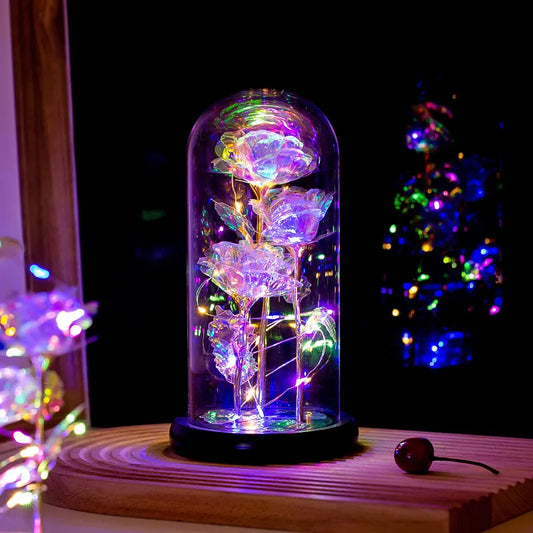 Galaxy Enchanted Rose Dome Decorative LED rose in a glass dome with colorful lights on a wooden surface.