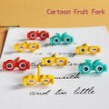 Goggles Food Pick Cartoon fruit forks with colorful designs on a piece of paper.