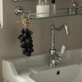 Handmade Grape Soap - Crystal Grape Soap hanging in wash basin.
Bathroom sink with chrome faucet and decorative grapes on a glass shelf.