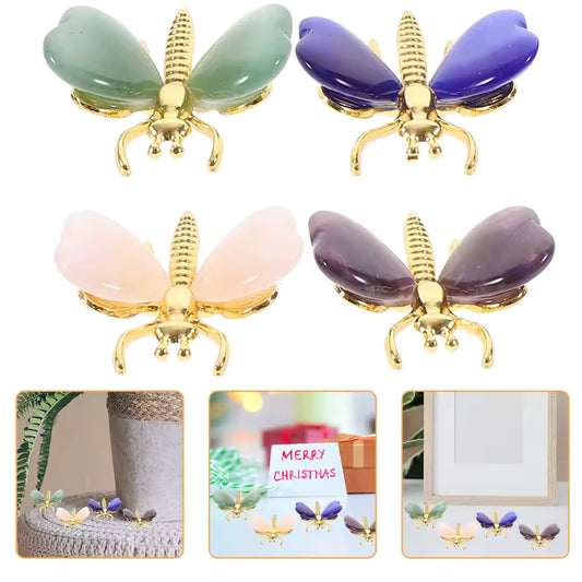 Heart Shaped Crystal Butterfly OrnamentFour butterfly-shaped hair claw clips in different gemstone colors (green, purple, pink, and dark purple) with gold-tone metal bodies and legs, shown on a white background with three small lifestyle inset photos at the bottom.