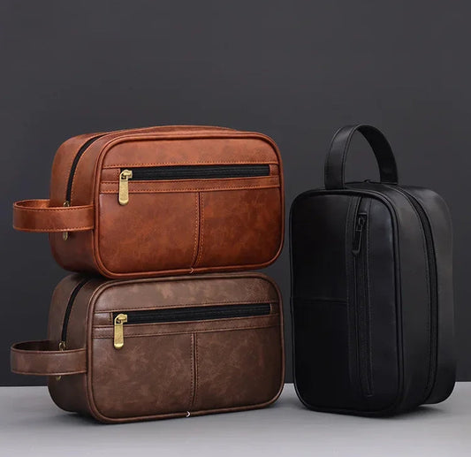 Leather Toiletry Bag | Premium Pebbled Leather Toiletry Bag Two brown leather bags and one black leather bag on a gray surface with a dark background