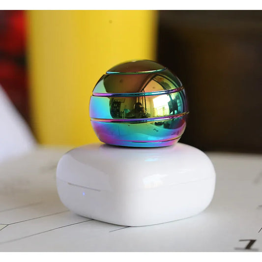 Metallic Rainbow Gyro Sphere Multicolored spherical object on a white base with a blurred background