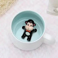 Peekaboo Animal Mug – Cute 3D Hidden Surprise Ceramic Coffee Cup
monkey variant GiftDealAU product image. Black bear figurine with a red bow tie in a white mug with a light blue interior.