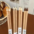 Plumpy Handmade Animal Chopsticks GiftDealAU product image. Set of wooden chopsticks with cat-shaped ends on a wooden surface.