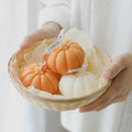 Pumpkin Shaped Soy Candles Pumpkin-shaped candles in a woven basket held by a person