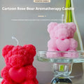 Rose Teddy Bear Soy Candle Red and pink Cartoon Rose Bear Aromatherapy Candles with a heart shape, displayed as home fragrance decor. Two teddy bear-shaped candles, one pink and one red, on a glass stand with a gray background.