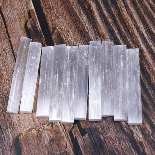 Selenite Rod Row of selenite sticks on a wooden surface
