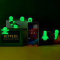 Smiski Hippers Blind Box glow in dark GiftDealAU product image. Glowing green decorative mini figures around a smartphone on a dark background