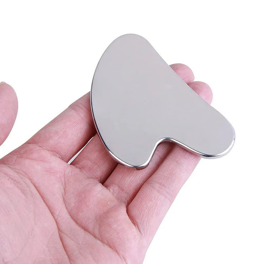 Stainless Steel Cool Gua Sha Heart-shaped silver tool held in a hand against a white background