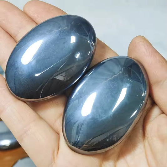 Terahertz Palm Stone Two blue stones held in a hand against a neutral background